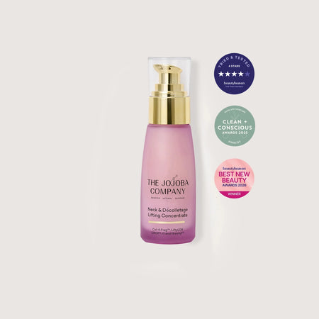 Pink skincare bottle with gold cap on a white background, featuring The Jojoba Company branding and awards.