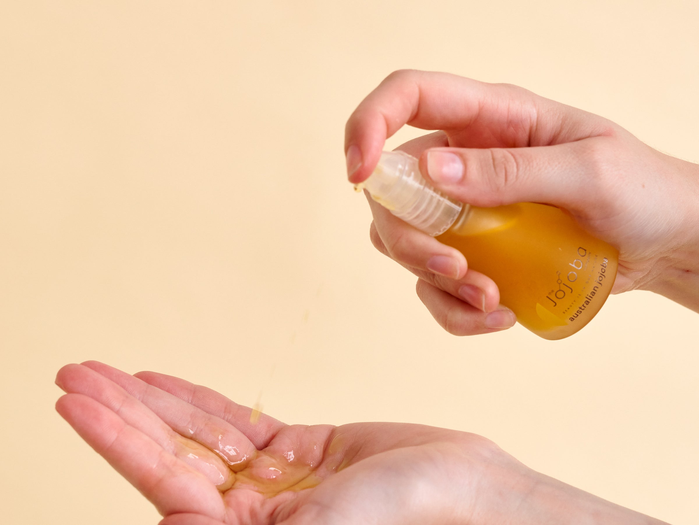 A person holding a bottle of lotion in their hands.