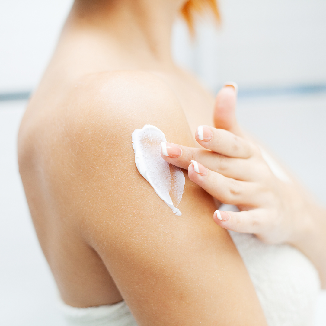 Person applying a skincare product to their shoulder.