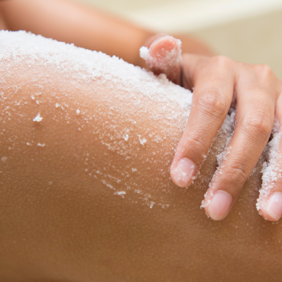 A woman relaxes in a white powder bath, showcasing a soothing jojoba product.