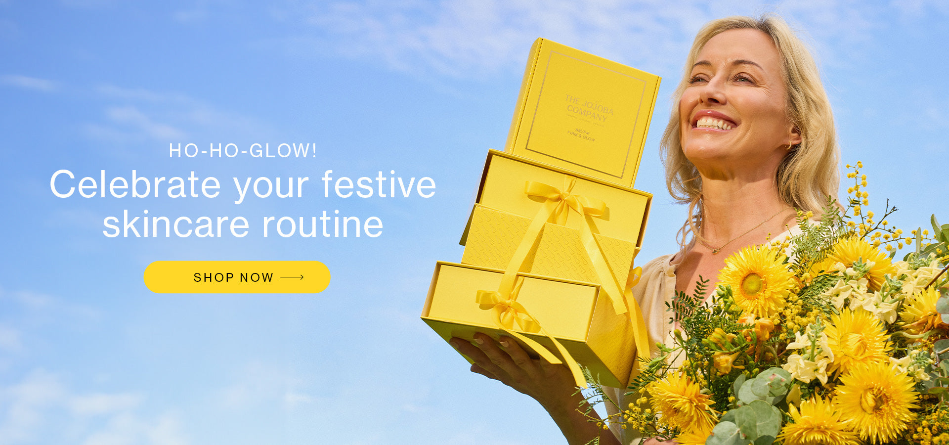 Person holding yellow gift boxes with text "Celebrate your festive skincare routine" and flowers.