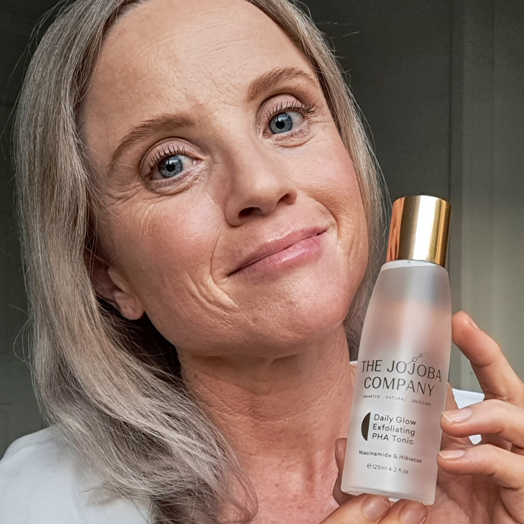 Person holding a bottle of The Jojoba Company Daily Glow Exfoliating Tonic.